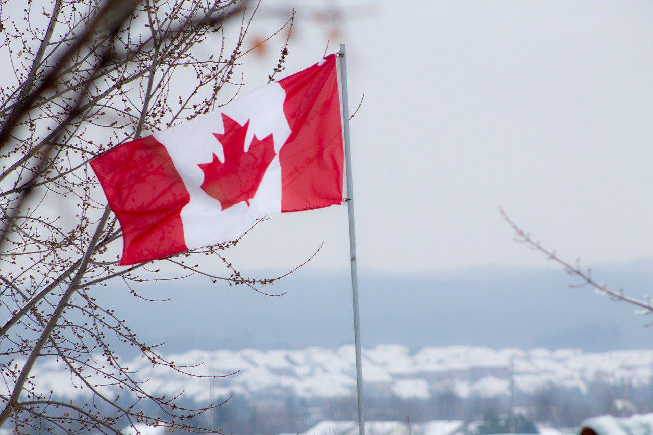 Image of a Canadian Flag with mountains in background