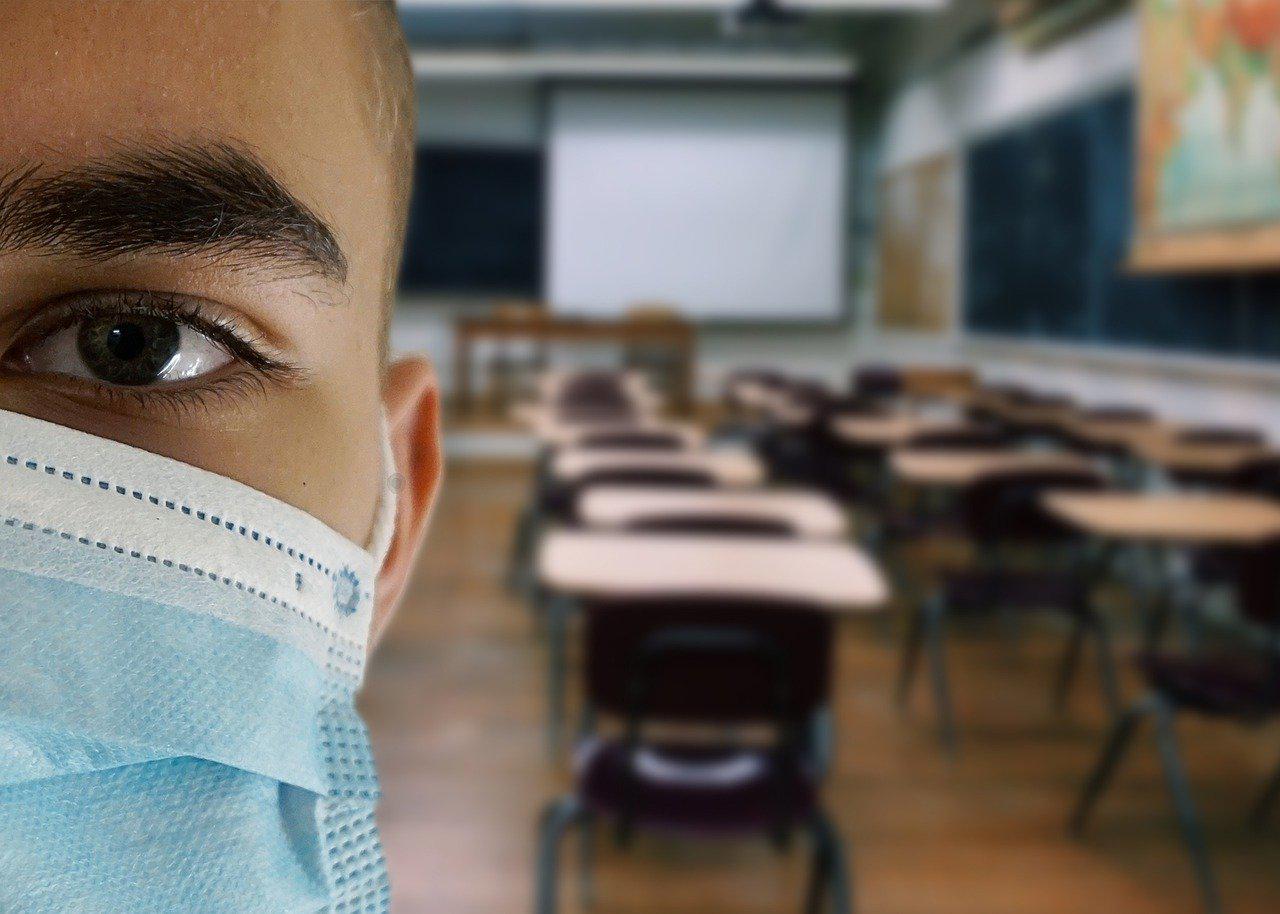 Image of masked person in classroom by Alexandra_Koch from Pixabay