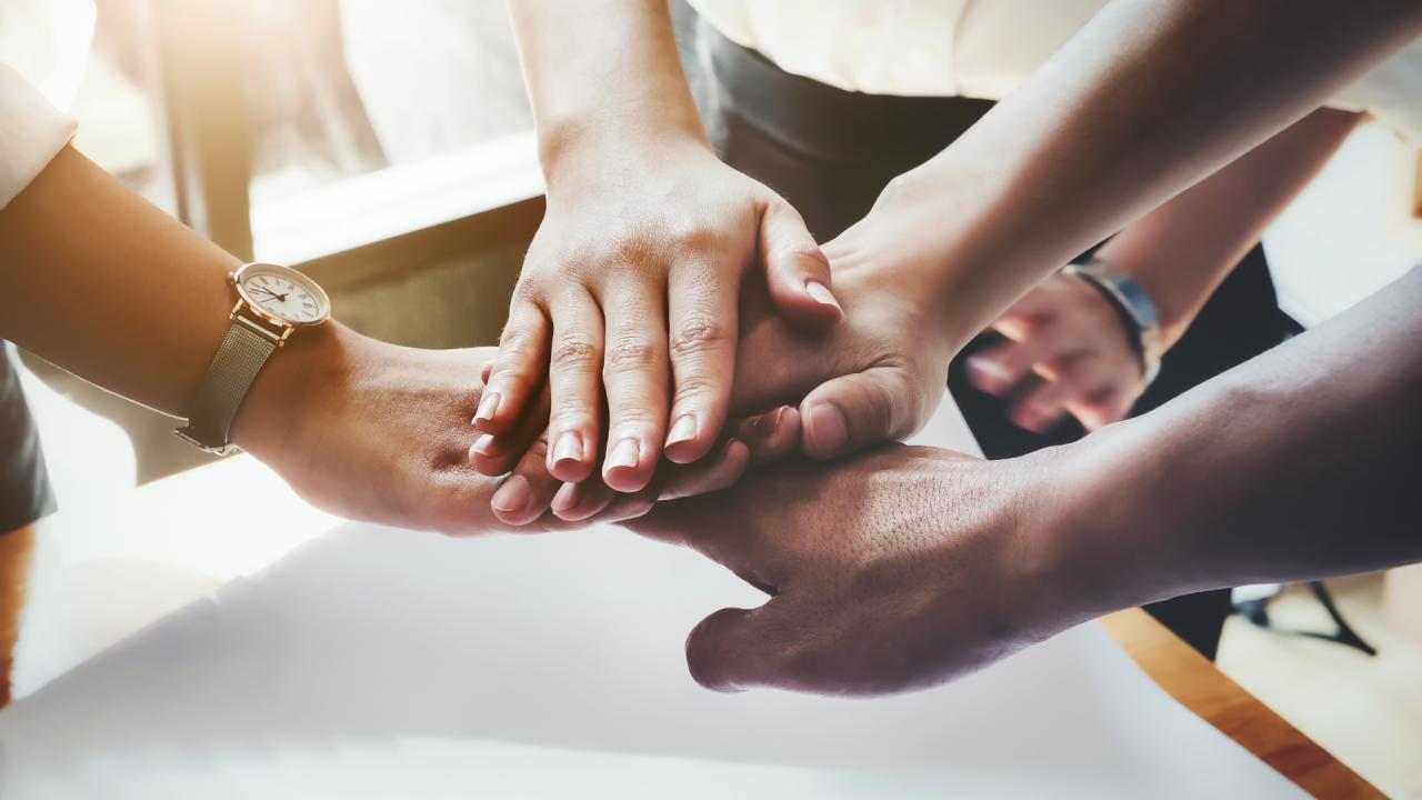 Hands one on top of the other in a collaborative and respectful fashion.