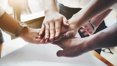 Hands one on top of the other in a collaborative and respectful fashion.